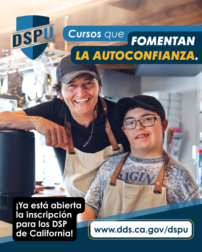 Dos personas, un profesional de apoyo directo y una persona con síndrome de Down, sonríen mientras trabajan en un restaurante o una cafetería.